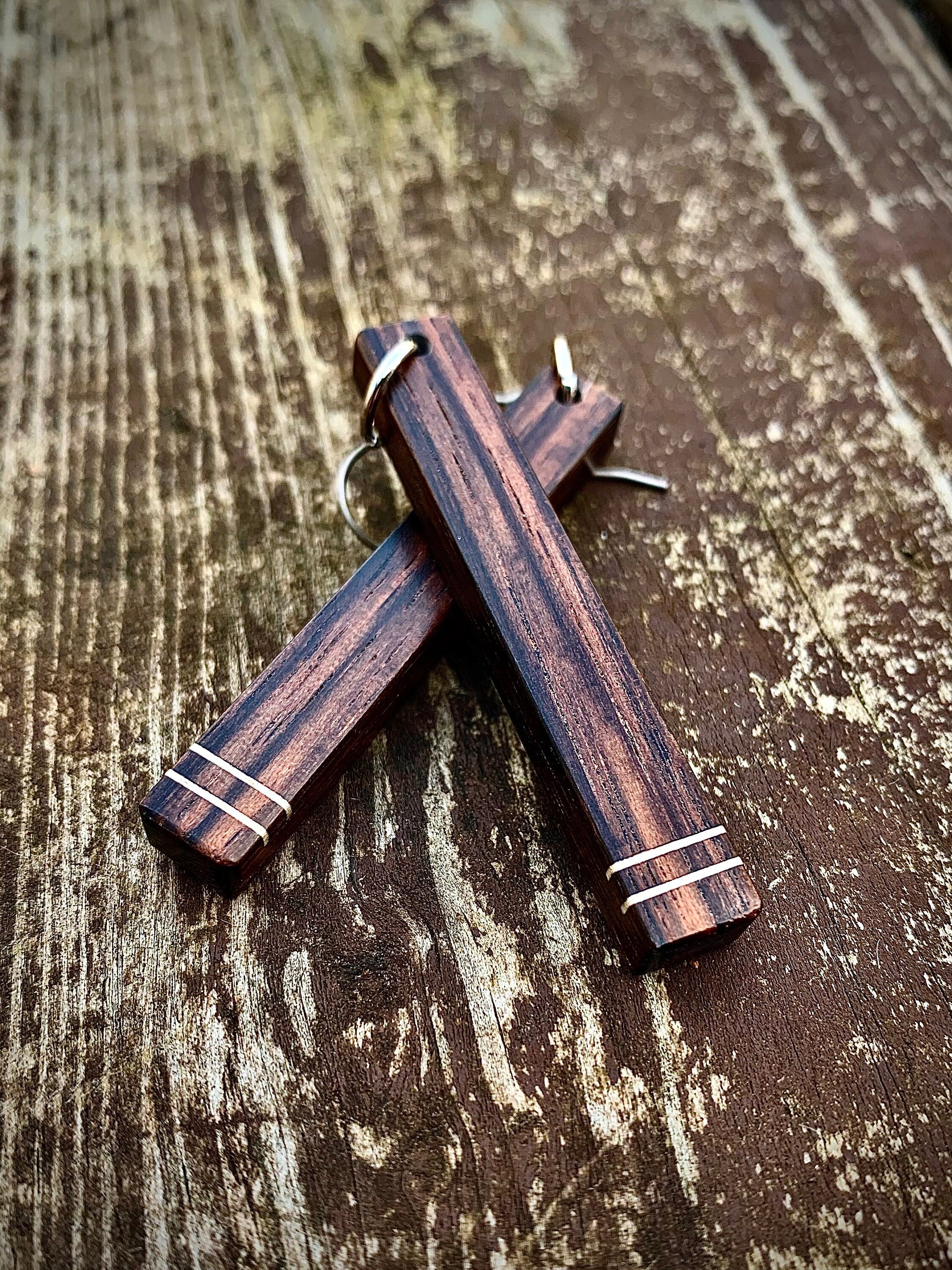 Two dark wood dangle earrings with two horizontal white stripes.
